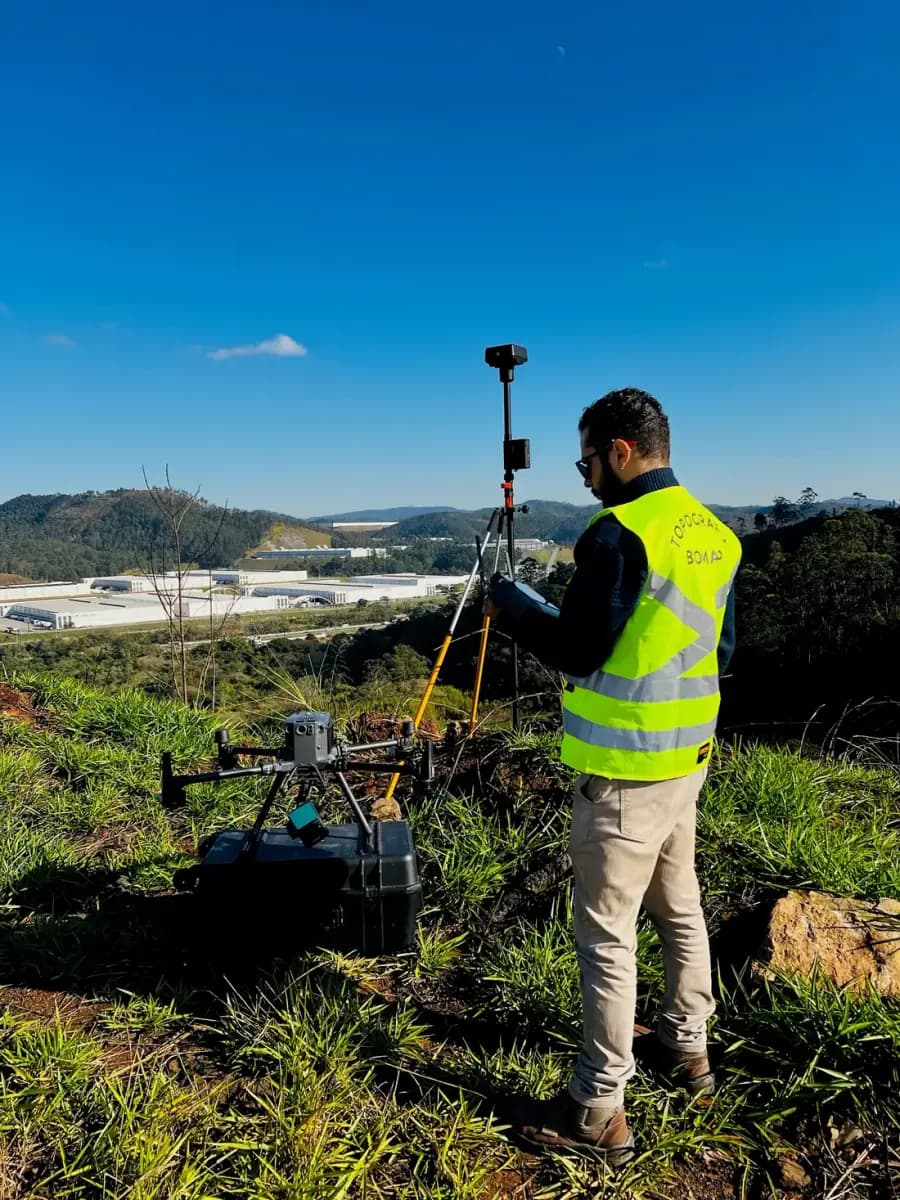 Drone pousado com base GNSS em primeiro plano, vale ao fundo